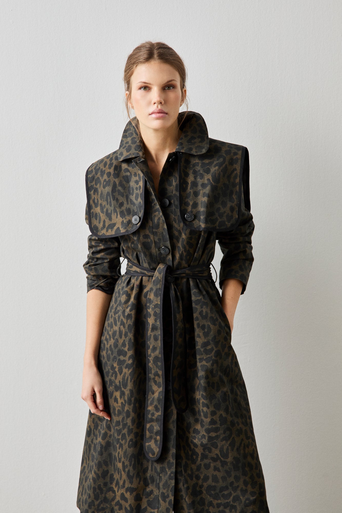 Gabardina de estampado animal print con detalle de vivos a contraste en color negro.