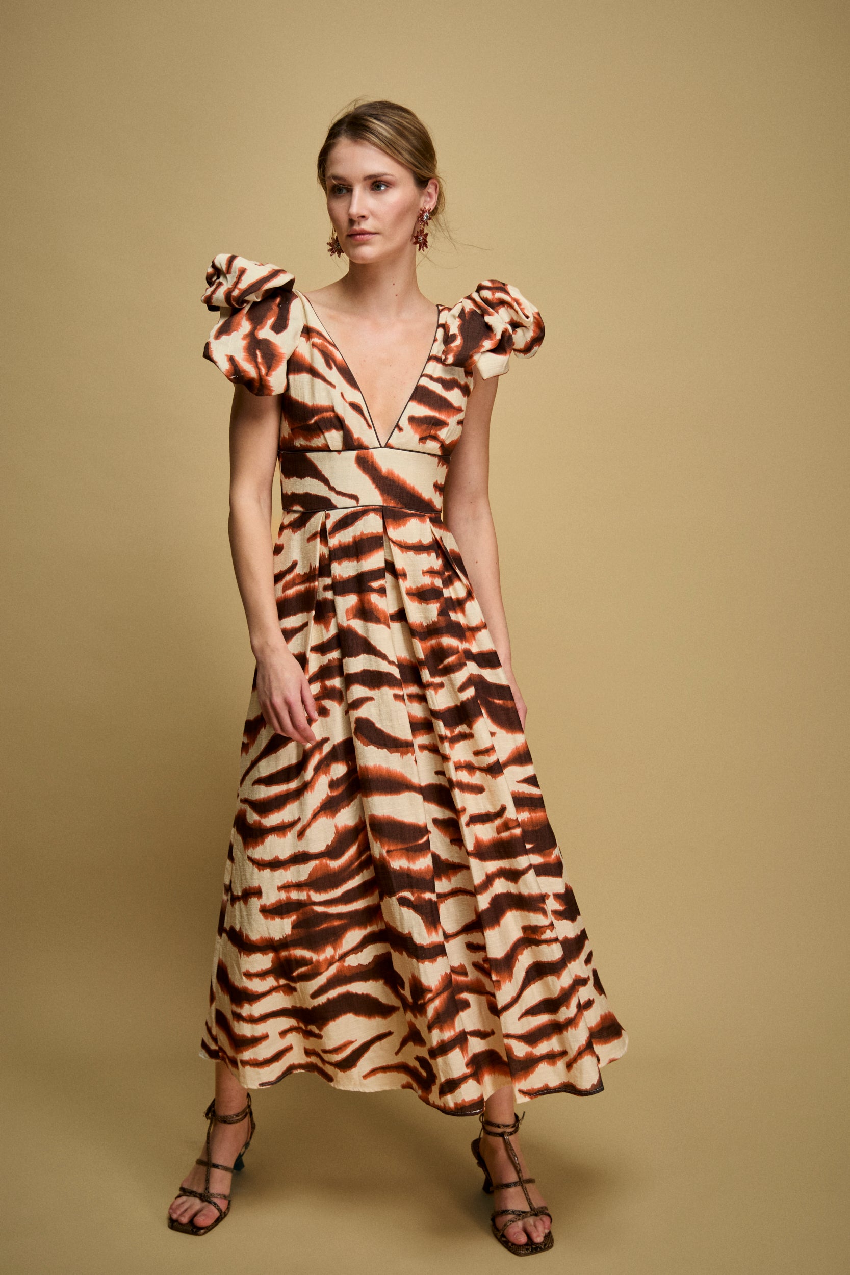 Vestido midi estampado en tonos marrones y teja con escote en V y lazadas en hombros.