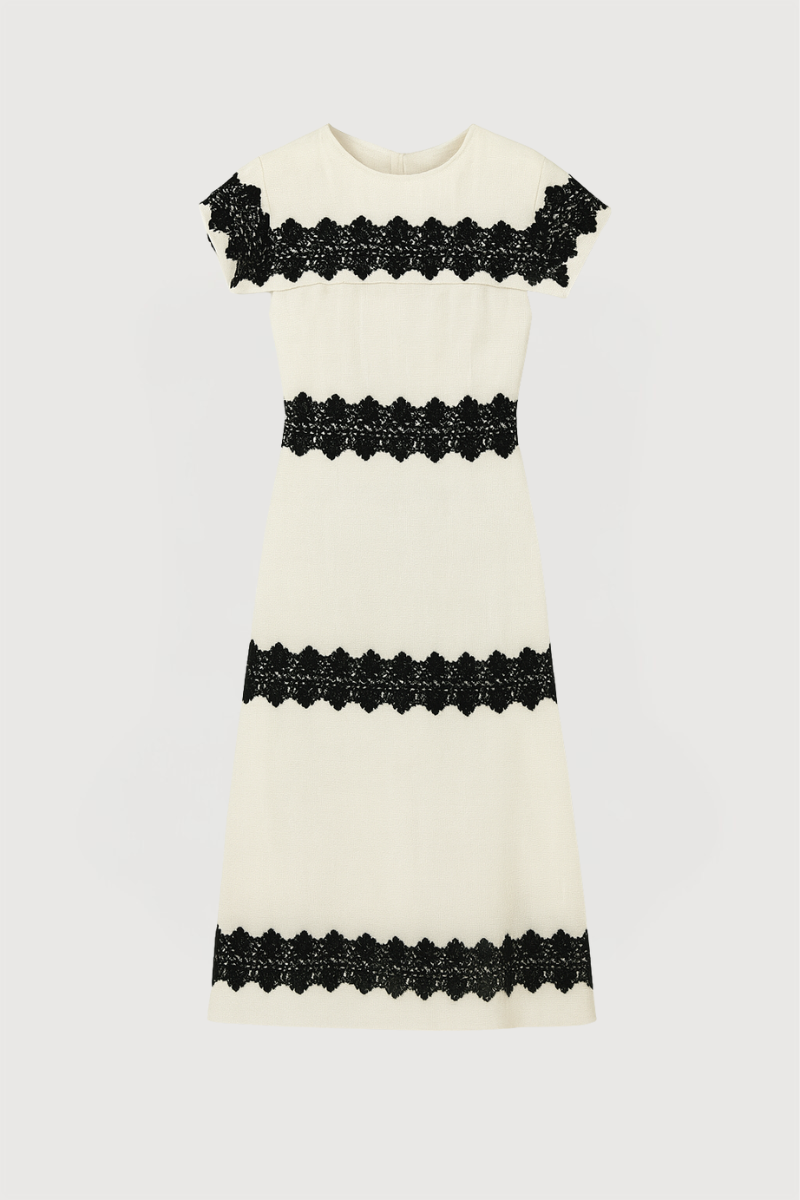 Vestido midi en color blanco con detalles de pasamaneria en negro.