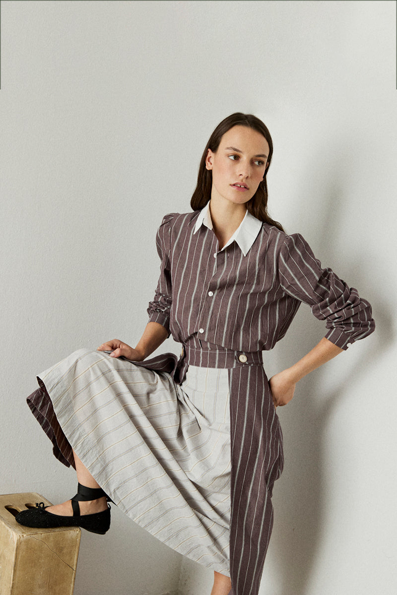 Camisa de rayas en color berenjena de manga larga, hombros rizados y puño abotonado. Con cuello camisero a contraste.
