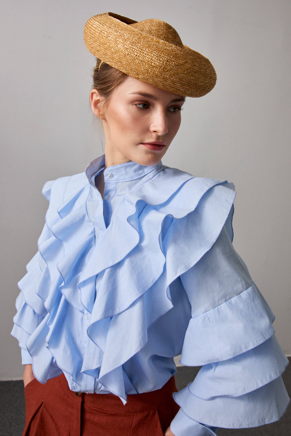 Camisa celeste de manga larga con volante en pecho y espalda.  