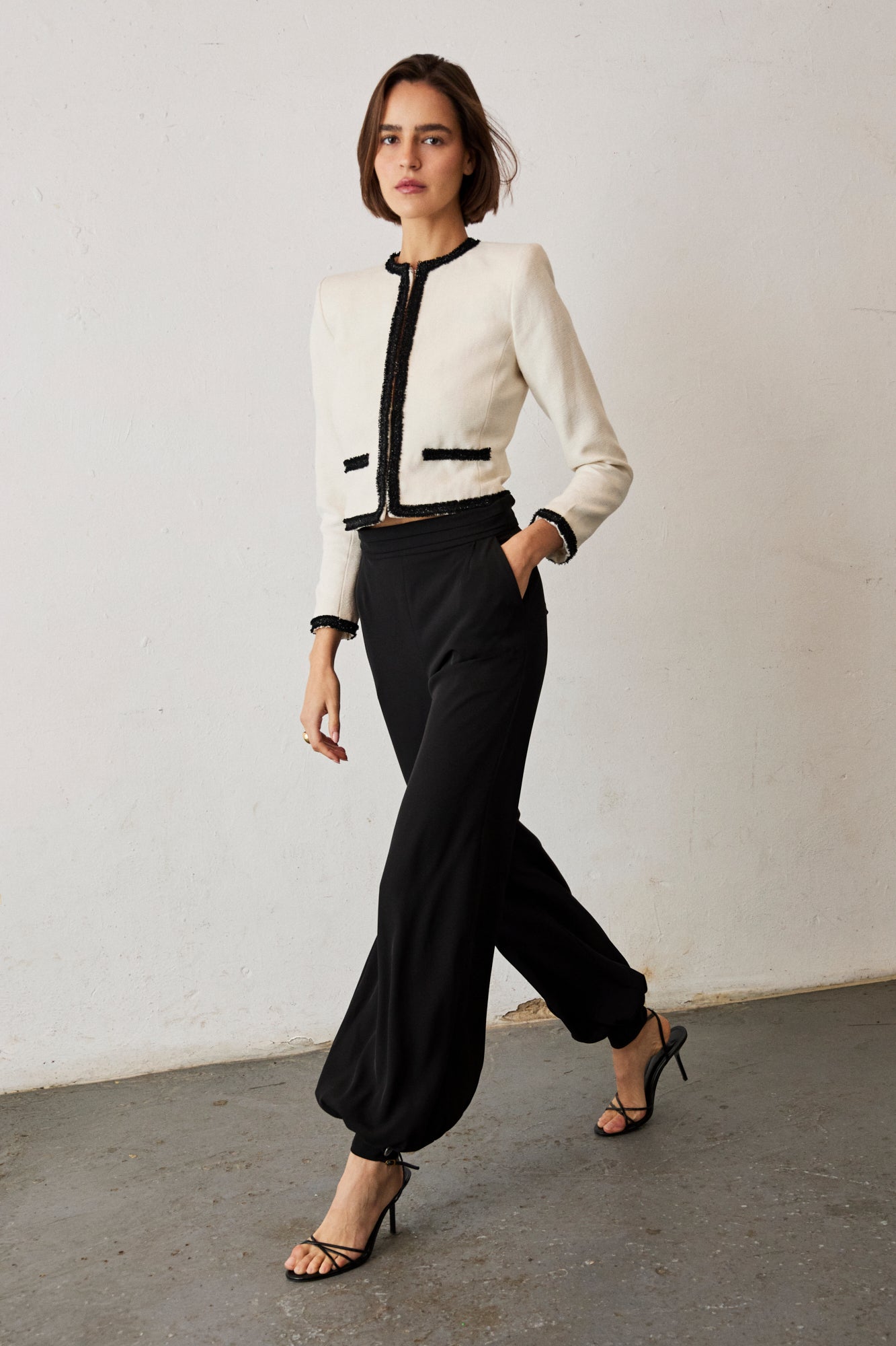 Chaqueta recta en color crudo viveada en negro con detalle de pasamanería