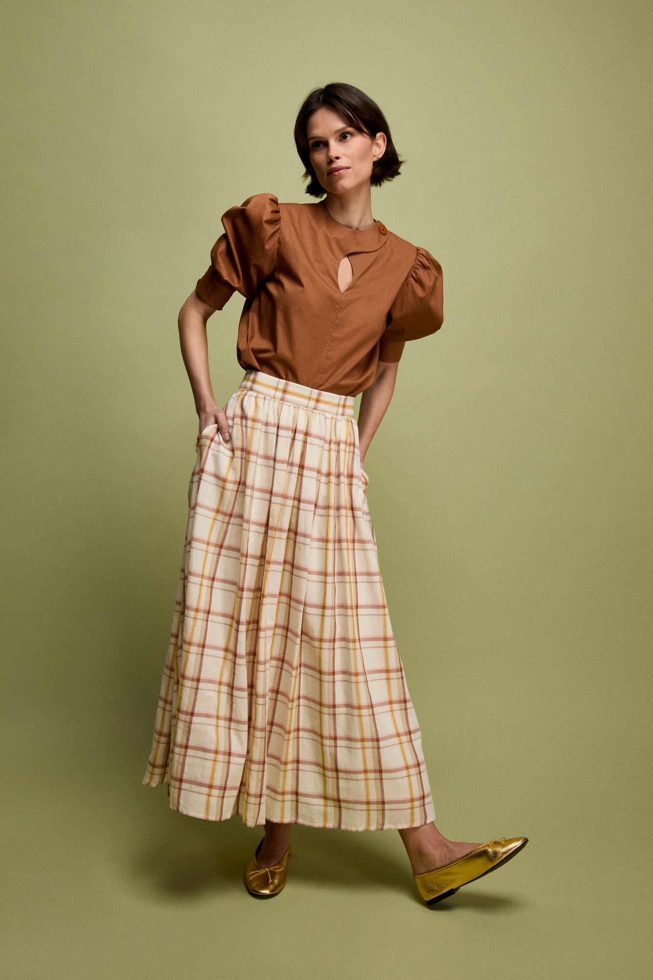 Blusa de algodón en color ocre con manga corta abullonada y puño ajustado.